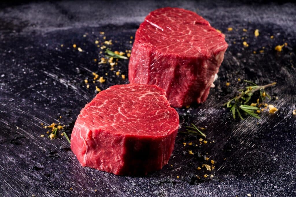 Wagyu tenderloin cuts showcasing rich marbling and vibrant red color on a textured surface, emphasizing premium quality for culinary applications.